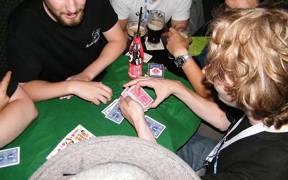 Friends sharing a casual card night around a green felt table