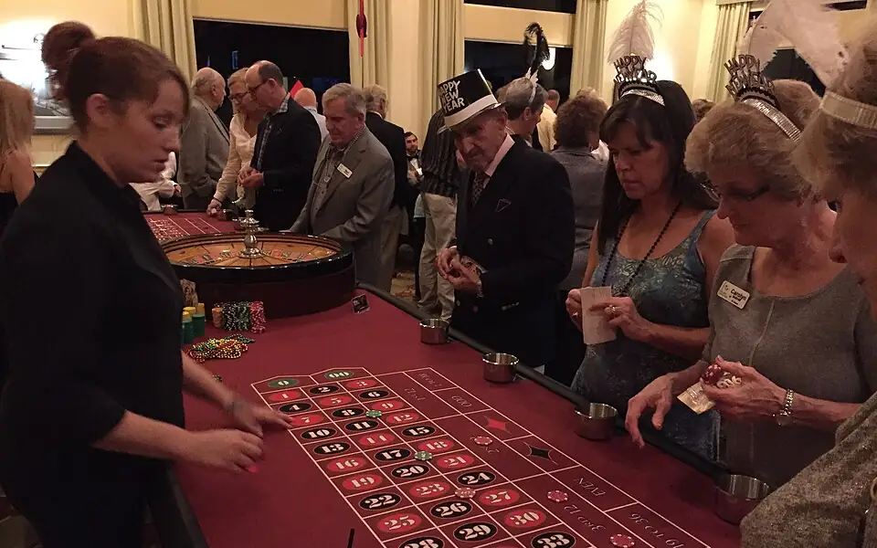 Dealer running a live roulette table while players place colorful chips